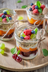 Fresh granola with fresh fruits and yoghurt in jar