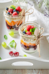 Homemade granola with fresh fruits and yoghurt in jar