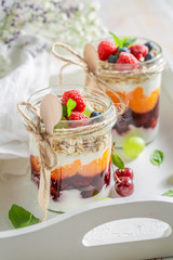 Delicious oat flakes in jar with yoghurt and berry fruits