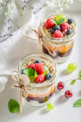 Tasty oat flakes in jar with yoghurt and berry fruits
