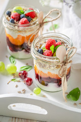 Healthy oat flakes in jar with yoghurt and berry fruits