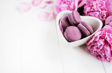 Obraz na płótnie Canvas Pink peony flowers with macarons