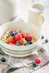 Healthy oat flakes with fruits for breakfast on rustic table