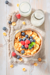 Healthy cornflakes with berry fruits and milk for breakfast