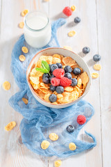 Fresh cornflakes with berry fruits and milk for breakfast
