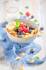 Sweet cornflakes with berry fruits and milk for breakfast