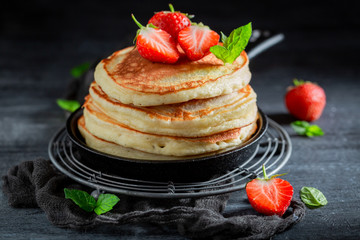 Homemade american pancakes with powdered sugar and strawberries