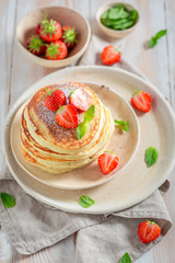 Delicious american pancakes with powdered sugar and strawberries