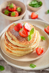 Sweet american pancakes with powdered sugar and strawberries