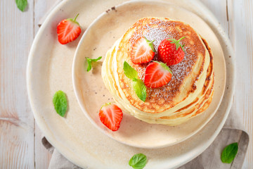 Tasty american pancakes with fresh strawberries and sugar