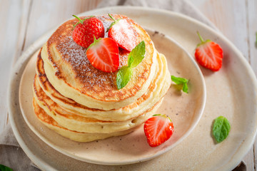 Yummy american pancakes with powdered sugar and strawberries