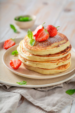 Delicious american pancakes with fresh strawberries and sugar