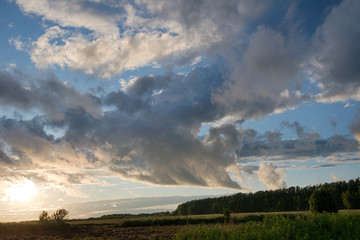 Clouds at sunset/ Clouds at sunset in a field after a rain