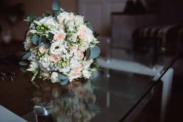 Wedding bouquet with red and white flowers standing on a glass table