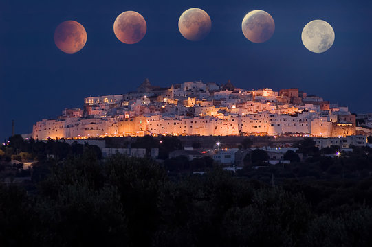 Ostuni in the night, the white city in Apulia, with total eclipse