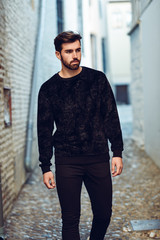 Fototapeta premium Young bearded man, model of fashion, in urban background wearing casual clothes.