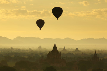 Fototapeta na wymiar The hot air balloon over plain for tourist and beautiful landscape pagoda ancient with misty morning time of Burma. The landmark tourism culture in Asian.
