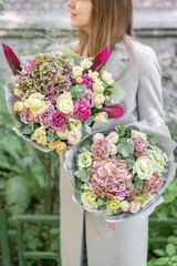 two beautiful spring bouquet. Young girl holding a flowers arrangements with various of colors. Bright dawn or sunset sun