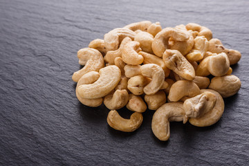 cashew nuts on a dark stone background