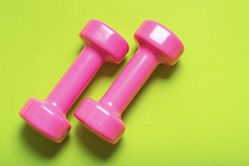 Pair of pink dumbbell on green color