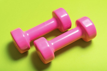 Pair of pink dumbbell on green color