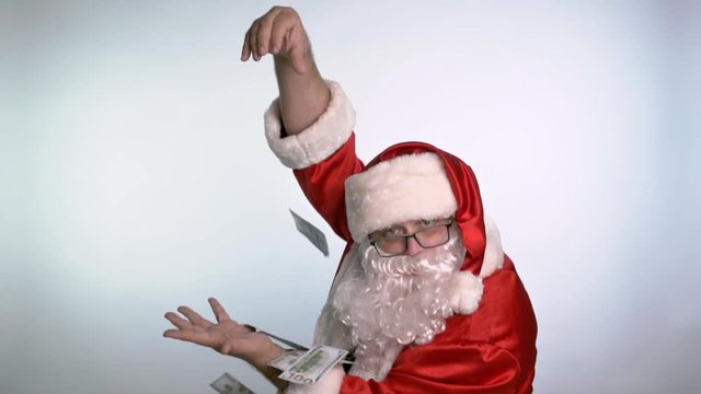 Santa Claus holds bills in his hands standing on a white background.
