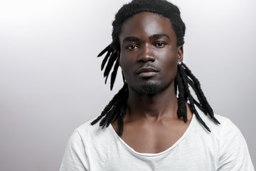 African American male with dreadlocks on white background looking at camera