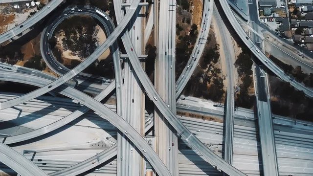 Top view lockdown shot of traffic moving through incredible complex multiple level road interchange in Los Angeles, USA.