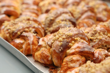 Fresh croissant in bakery on metal drip tray background