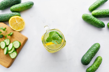 Summer cocktail cucumber lemonade. Refreshing water with cucumber, mint and lemon on grey background. Healthy drink and detox concept. Copy space