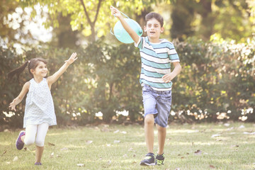 Obraz premium Kids playing with a balloon in the park. Children having fun outdoors concept