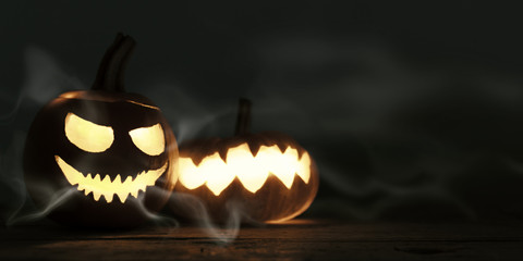Halloween Dekoration auf Holz Untergrund, geschnitzte Kürbisse mit grusligen Fratzen und...