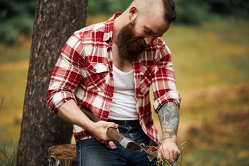bearded axeman wipes clean axe with leaves