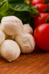 Mozzarella tomatoes and basil on a wooden rustic background