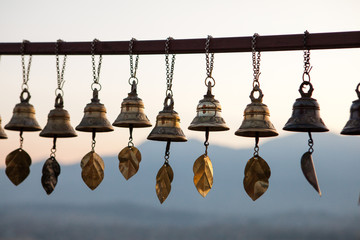 Prayer Bells at Svayambunath Stupa in Kathmandu, Nepal with Himalayas on background at sunset