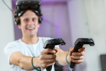 Fototapeta na wymiar A young, handsome guy plays virtual reality games