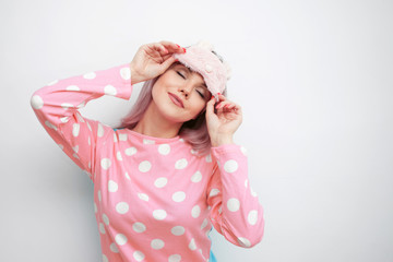 Beautiful young blonde in pink pajamas and a sleep mask