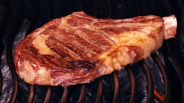 UHD closeup shot of the juicy beef steak on a barbecue grill
