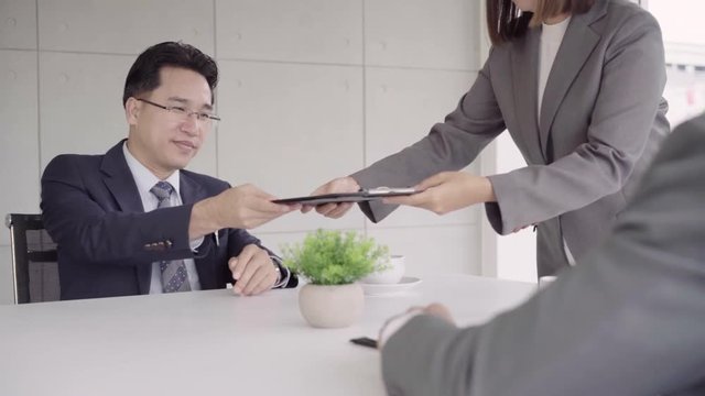 Slow motion - Beautiful woman secretary giving document to businessman to signing a contract, recruitment and agreement concept. Businessman making a deal.