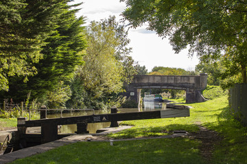 Moored narrow boat with bridge and lock on the Trent and Mersey canal in Cheshire UK