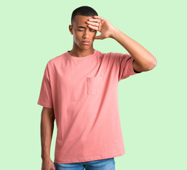 Dark skinned man with tired and sick expression on green isolated background