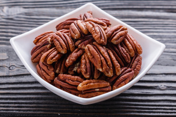 delicious pecan nuts on a rustic wooden background