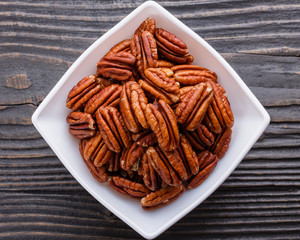 delicious pecan nuts on a rustic wooden background