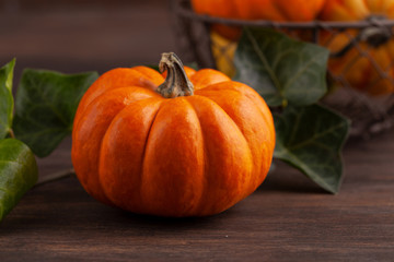 Pumpkins and leaves over wooden background copy space. Template fall harvest thanksgiving halloween invitation cards.