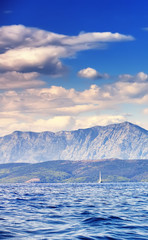 Beautiful sea landscape, sailboat sailing on the distance on great majestic mountains background, romantic cruise in the Adriatic sea, Croatia