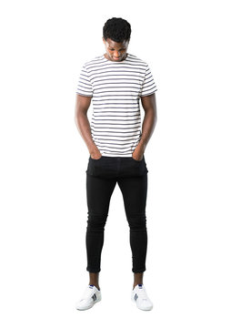 Full body of Dark skinned man with striped shirt standing and looking down on white background