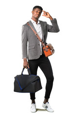 Full body of African american business man traveling with suitcases having doubts and with confuse face expression while scratching head on white background