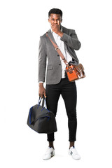 Full body of African american business man traveling with suitcases covering mouth with both hands for saying something inappropriate. Can not speak on white background