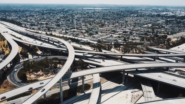 Drone flying left high above big Judge Pregerson freeway junction in Los Angeles with multiple bridges and flyovers.