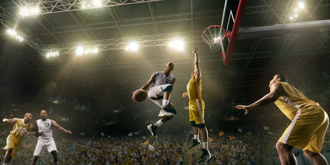 Basketball players on big professional arena during the game. Basketball player makes slum dunk. Bottom view © Alex